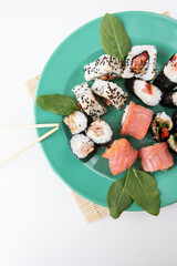 Various types of maki sushi, philadelphia, maki, salmon, rice, salad. Delicious and healthy food. Close-up, top view.