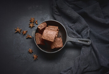 pieces of baked brownie in a metal black frying pan on the table