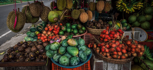 Fruit shop in Thailand. Fruit market in Indonesia Bali island. Street bazaar in Asia. Sale of fresh fruits and vegetables at the market in Thailand. A small grocery store on the street of Bali island