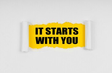 A window is made in the paper, where on a yellow background the inscription - It Starts With You