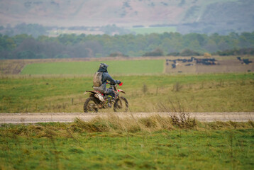 a motor cyclist (biker) riding his off-road motorbike along a stone track on Salisbury Plain, Wiltshire