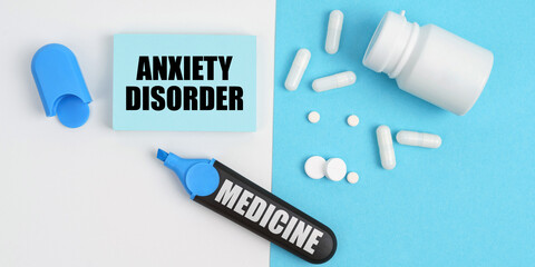 On the white and blue surface are pills, a marker and paper with the inscription - ANXIETY DISORDER