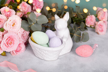 Easter bunny, colored eggs and pink flowers. Festive easter card with free text space