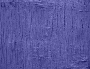 Demonstrating the fashionable color of 2022 - purple. A background of purple, peeling paint on an old wooden wall.