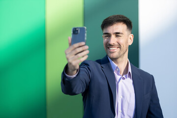 Close-up view of a young business man smiling taking a selfie wearing a suit