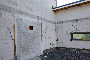Facade of white block building under construction works.