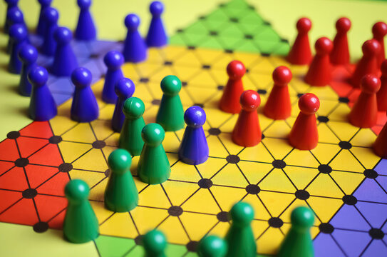 Closeup of gameboard with hexagram, colorful pieces of strategy game sternhalma or chinese checkers