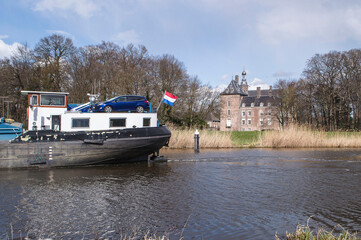 Dutch cargo boat sails past castle of Laag Keppel on river Oude IJssel