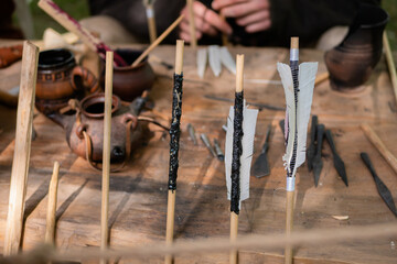 Homemade wooden archery arrows with fletching at medieval historical outdoor festival - close up,...