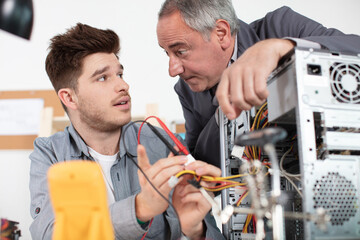trainee technician learning how to wire up a computer