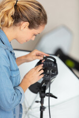 photographer woman with wide range of different lighting equipment flash