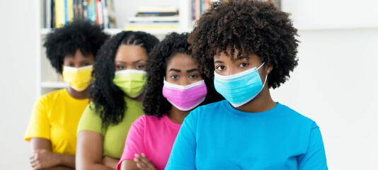 Group of careful african american female young adults with colorful face masks