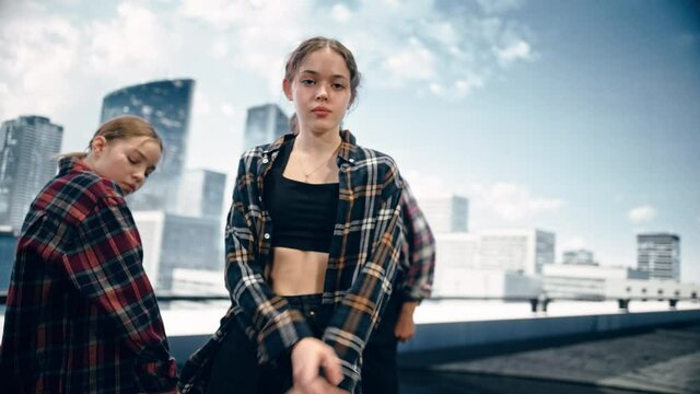 Diverse Group of Three Professional Dancers Performing a Slow Improvisation Dance Routine in Close Up in Front of a Big Led Screen with City Skyline with Office Skyscrapers in Studio Environment.