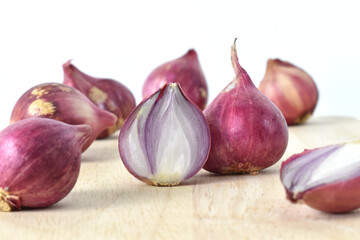 Group of organic shallot slice on wooden cutting board on white background