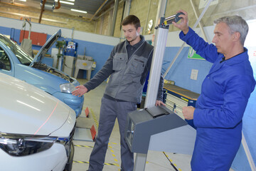 teacher and student in auto mechanics training class