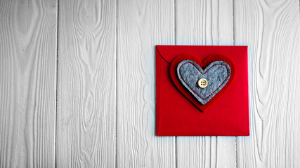 Red envelope with hearts. There is a button on the heart. Envelope on a white background. Valentine's Day.