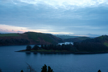 Fototapeta na wymiar Lake in the evening. Sunset. Clouds. United Kingdom, Wales in late winter.