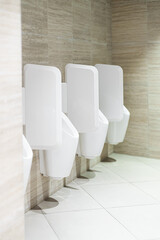 Row of urinals in public restroom.
