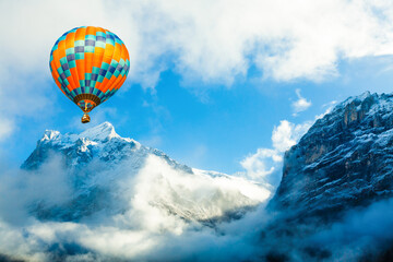 Colorful hot-air balloon flying over snowcapped mountain