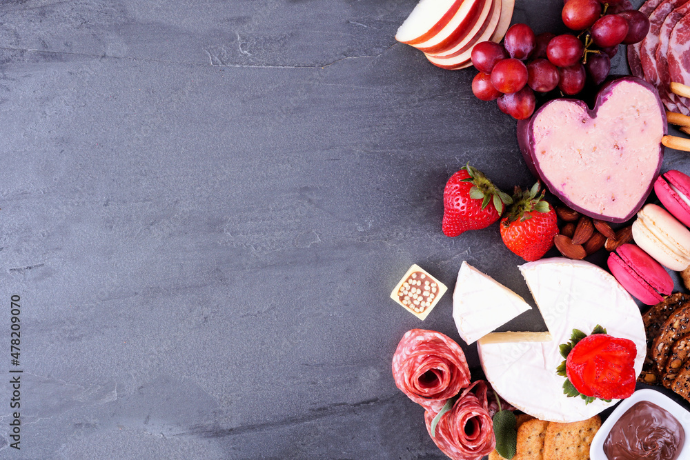 Poster valentine's day theme charcuterie side border. top down view on a dark slate background. copy space.