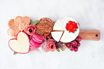 Valentine's Day charcuterie board with a selection of cheeses, appetizers and fruit. Above view on...