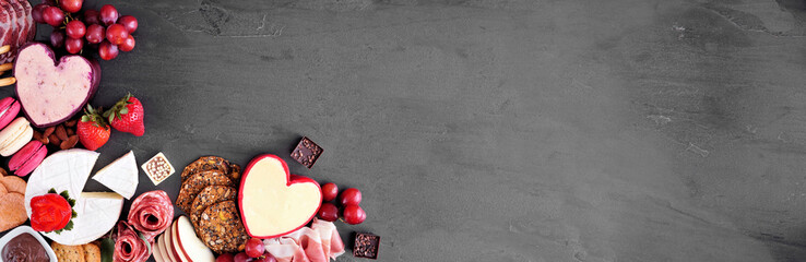Valentine's Day theme charcuterie corner border. Top view over a dark slate banner background. Copy...