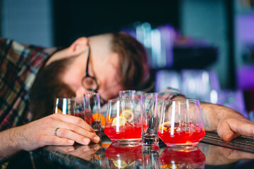 Drunk bearded man fell asleep at the bar.