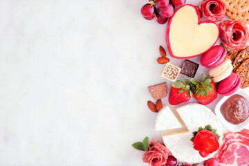 Valentine's Day theme charcuterie side border. Overhead view against a white marble background....