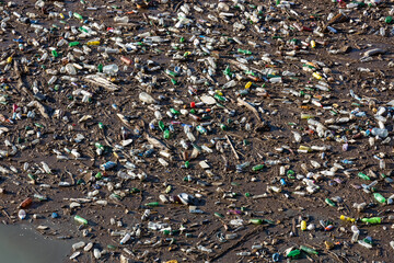 Plastic bottles in water. The river polluted with rubbish. Waste floating on the water surface. Garbage heap. Global environmental problem. Contaminated Avar Koysu river in Dagestan, Russia.