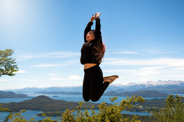 Mujer saltando en el cerro Lopez, en el circuito chico de la ciudad de Bariloche. Patagonia...