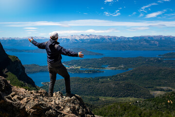 Hombre admirando las vistas de los lagos de Bariloche desde cerro de gran altura