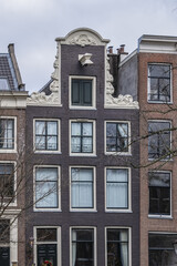 Close-up view details of old colorful building (XVI- XVIII centuries) with gable rooftop and hook along Prince's Canal (Prinsengracht) canal in Amsterdam. Amsterdam, the Netherlands.