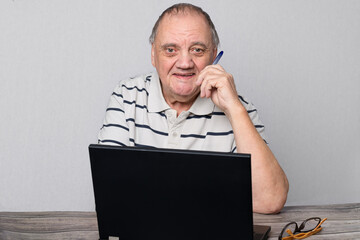 Portrait homme âgé devant son ordinateur portable