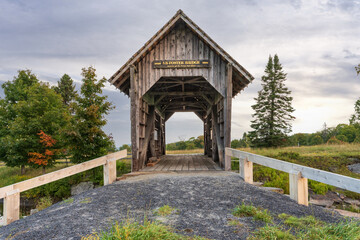 The Am Foster Covered bridge in early fall Cabot county vt a tourist spot  and place for wedding photos off in a Vermot field with views of the surrounding hills
