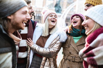 Young people wearing winter clothes having fun on city street - Group of happy friends socializing...
