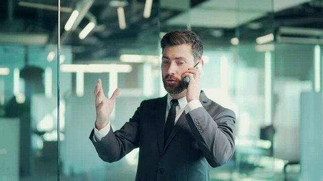 angry evil male businessman cry talking on the mobile phone in office. business man shouting on call indoor. Nervous mad professional conversation on smartphone. Irritated employee worker scream speak