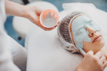 Close up portrait of a woman having a alginate mask on her face in a spa salon. Skin care procedure.