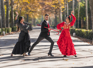 Man with two female flamenco dancers dancing on a park - obrazy, fototapety, plakaty
