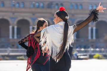 Back of two woman dancing flamenco outdoors - obrazy, fototapety, plakaty