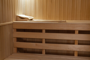 Bench and walls in a small home sauna sheathed with clapboard from  natural linden wood.