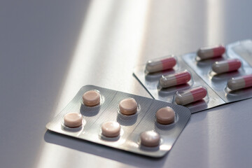 Obraz na płótnie Canvas 窓際のテーブルに置かれた錠剤とカプセル剤 