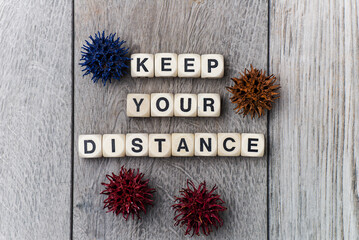 KEEP YOUR DISTANCE - lettering from cubes on a gray background. Personal Safety with omicron and...
