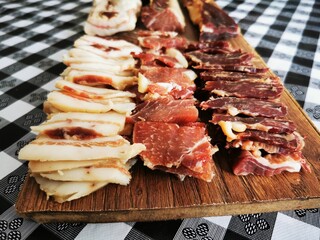 Cutting board with prosciutto, dried meat and bacon. Cold appetizer