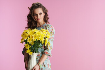 pensive elegant 40 years old woman in floral dress on pink