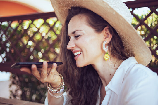 smiling elegant woman in shirt talking on phone