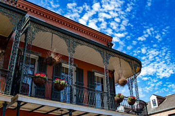 Beautiful Sky Behind a Balcony with Red Geranium Flower Pots in the French Quarter of New Orleans, Louisiana, USA