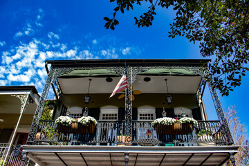 An American Flag Waves on a Balcony with White Petunias in Flower Boxes in the French Quarter of...