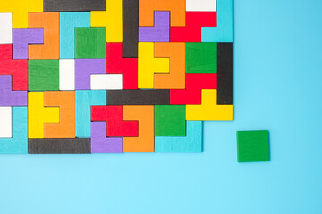 colorful wood puzzle pieces on blue background, geometric shape block. Concepts of logical thinking, Conundrum, solutions, rational, strategy, world logic day and Education