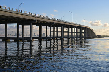 Rickenbacker Causeway bridge in Miami, Florida reflected in calm water of Biscayne Bay on clear...