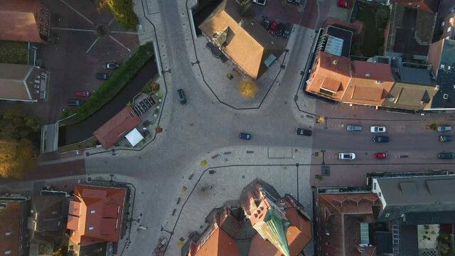 Aerial View Of Cars Driving In The Road In Front Of St.-Marien-Kirche Church At Friesoythe Town In Germany.